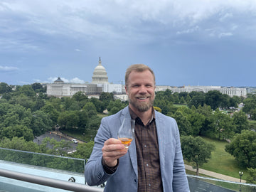 Leigh holding a glass of Backwoods whisky at Capitol Hill