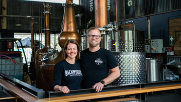 Backwoods Founders stand in front of a copper still